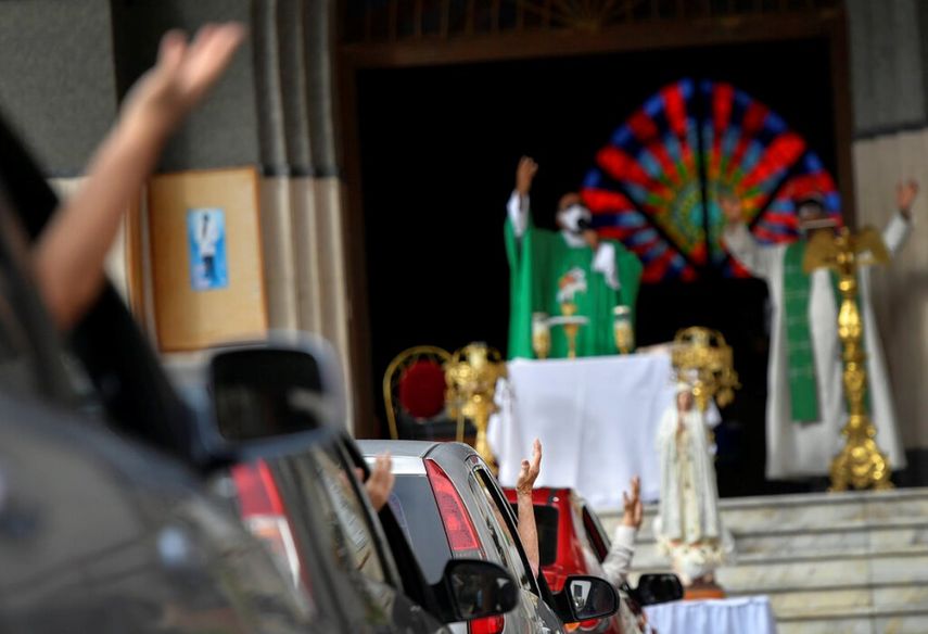 Feligreses asisten a una misa dominical en autocine montada por el padre Jonathan González para eludir las normas que impiden las concentraciones en los templos religiosos, en un estacionamiento en Caracas.
