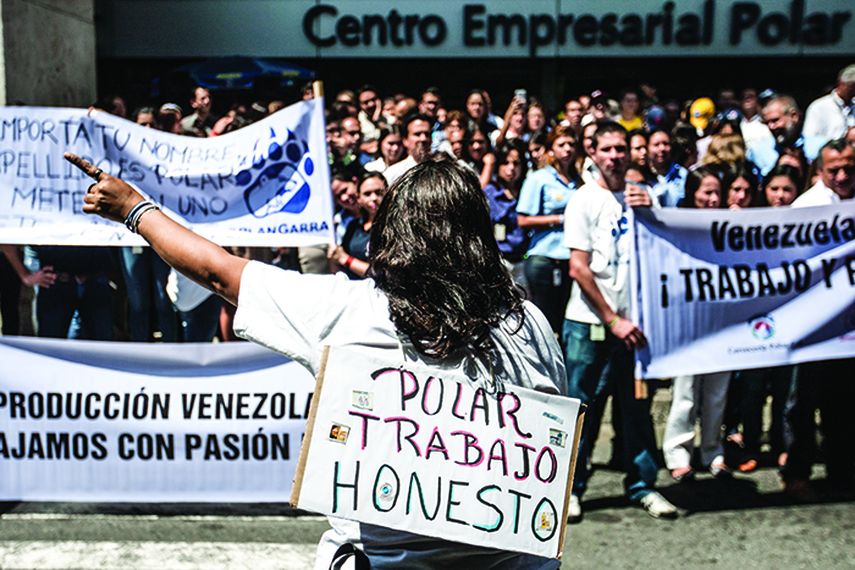 Una mujer con un cartel que dice Polar trabajo honesto protesta junto a un grupo de trabajadores de la empresa venezolana Polar para pedir que cesen los ataques contra la empresa en Caracas. (EFE)