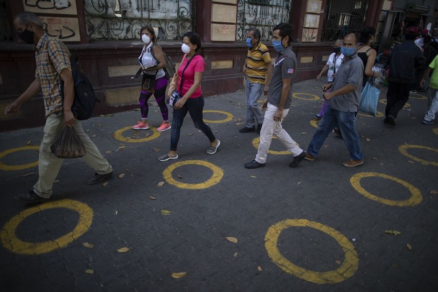 C&iacute;rculos amarillos en el pavimento sirven de gu&iacute;a para que los compradores mantengan la distancia social mientras esperan en fila, para evitar la propagaci&oacute;n del coronavirus, cerca de un popular mercado de Caracas, Venezuela, el 23 de mayo de 2020.&nbsp;