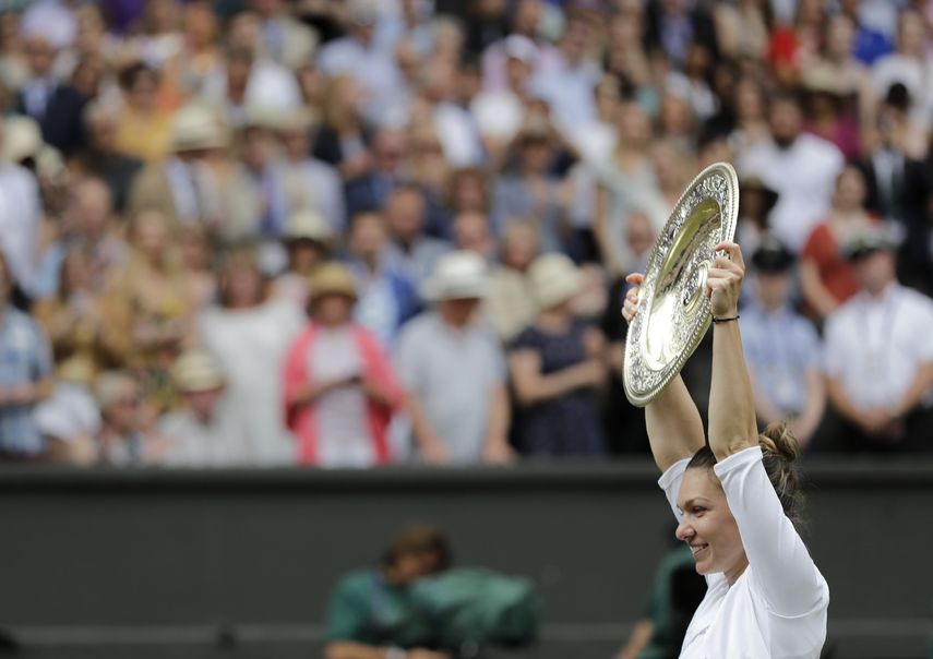La rumana Simona Halep alza el trofeo de campeona después de derrotar en la final de Wimbledon a Serena Williams, el sábado 13 de julio de 2019, en Londres.