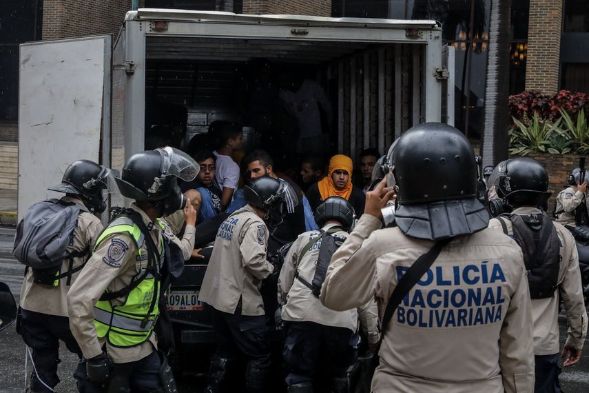 Agentes de la Policía Nacional Bolivariana detienen a manifestantes durante una marcha hacia la sede del Poder Electoral y los colocan en un camión cerrado sin ventilación.&nbsp;