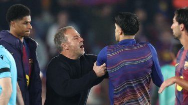 El técnico alemán del Barcelona, ​​Hans-Dieter Flick, impide que el defensa portugués Joao Cancelo, número 2 del equipo, hable con el árbitro al final del partido de ida de los cuartos de final de la Liga de Campeones de la UEFA entre el FC Barcelona y el Club Atlético de Madrid, disputado en el Camp Nou de Barcelona el 8 de abril de 2026. El Atlético de Madrid ganó 0-2.