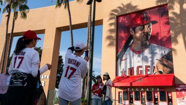 Aficionados toman fotos de una enorme imagen del astro de los Angelinos de Los Ángeles, Shohei Ohtani, antes del juego contra los Rangers de Texas, el miércoles 27 de septiembre de 2023, en Anaheim, California.