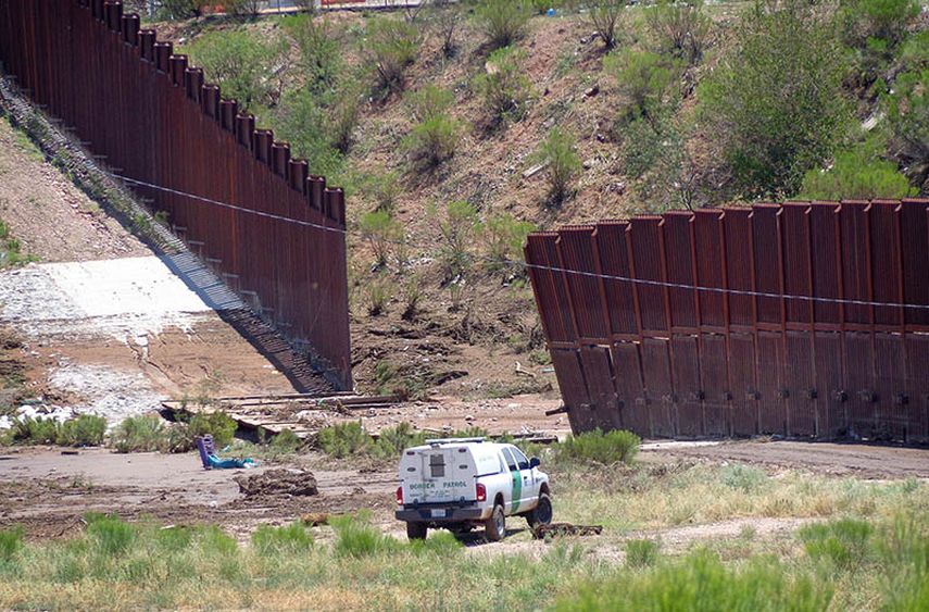 Un vehículo de la Patrulla Fronteriza vigila una sección colapsada de la valla fronteriza en Nogales, Arizona, el domingo 27 de julio de 2014 después que intensas tormentas derribaran una sección de la cerca que divide a México y Estados Unidos. (AP)