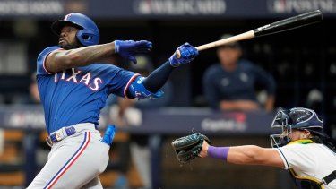 Adolis García (izquierda), de los Rangers de Texas, batea contra los Rays de Tampa Bay en el primer juego de la Serie de Comodines en los playoffs, el 3 de octubre de 2023.