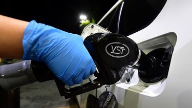 Un cliente repone combustible en su auto.