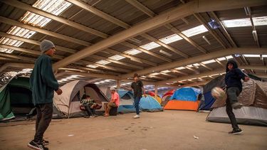 Varios migrantes centroamericanos juegan y pasan el tiempo en un albergue de la ciudad de Tijuana, México.