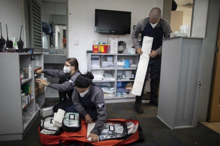 De izq. a der., los socorristas voluntarios de la organización Ángeles de las Vías Laura Lara, Zully Rodiz y Jonathan Quantip preparan el equipo para emergencias en la oficina de la agrupación el 8 de febrero del 2021 en Caracas.