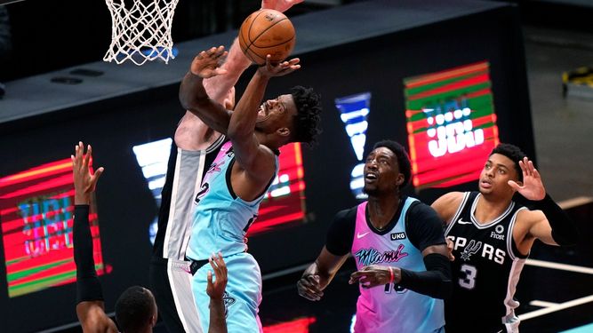 Jimmy Butler, alero del Heat de Miami, salta para encestar frente a Jakob Poeltl, de los Spurs de San Antonio, en el duelo del miércoles 28 de abril de 2021&nbsp;