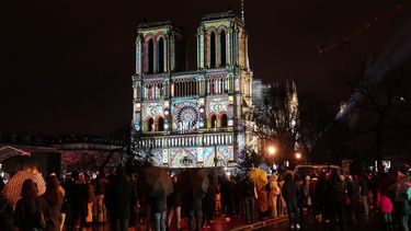 Una multitud se reúne en el exterior de la catedral de Notre Dame mientras se ilumina durante una ceremonia para conmemorar la reapertura de la emblemática catedral, en el centro de París, el 7 de diciembre de 2024.    