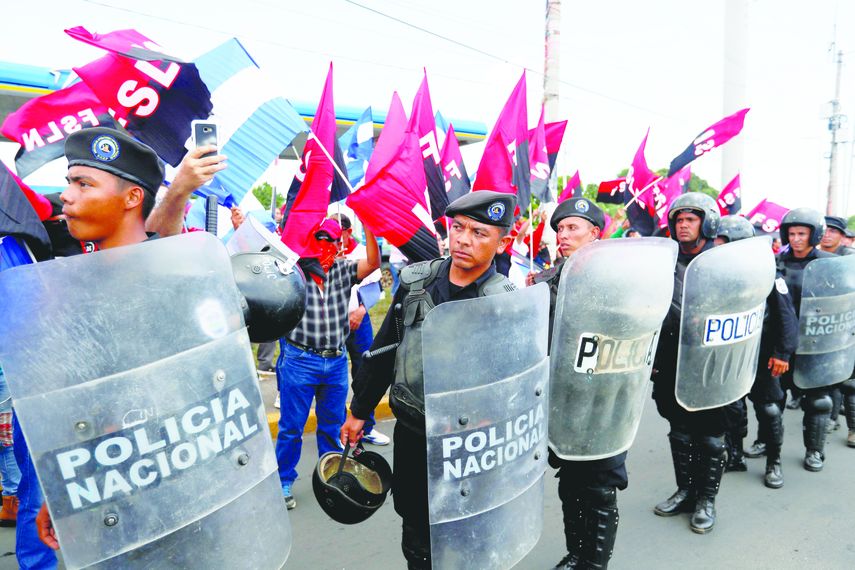 Miembros de la Policía Nacional establecen un cordón de seguridad contra manifestantes.