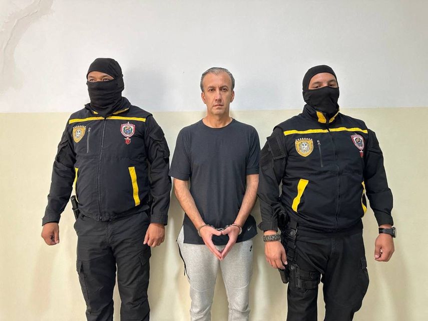 Esta fotografía, difundida por la Fiscalía General de Venezuela el 9 de abril de 2024, muestra al exministro de Petróleo venezolano Tareck El Aissami (C) escoltado por miembros de la Policía Nacional Anticorrupción tras su arresto en Caracas.