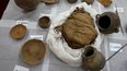Momias infantiles aparentemente sacrificadas para acompañar a un noble muerto al más allá y vasijas descubiertas recientemente por arqueólogos que trabajan en la segunda ciudad preincaica más grande de Perú se exhiben para una presentación ante los medios en la Universidad de San Marcos, en Lima, el martes 22 de febrero de 2022.