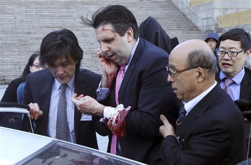 El embajador estadounidense en Corea del Sur, Marcos Lippert, centro, se mete en un coche para ir a un hospital de Seúl, Corea del Sur, después de ser atacado por un hombre. Lippert se redujo en la cara y la muñeca por un hombre blandiendo una espada y
