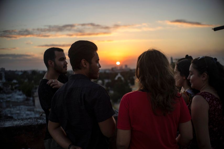 Marcos Marzo, segundo desde la izquierda, habla con sus amigos que vinieron a despedirse de él luego de recibir la noticia de que obtuvo un permiso para viajar a Estados Unidos, en La Habana, Cuba.