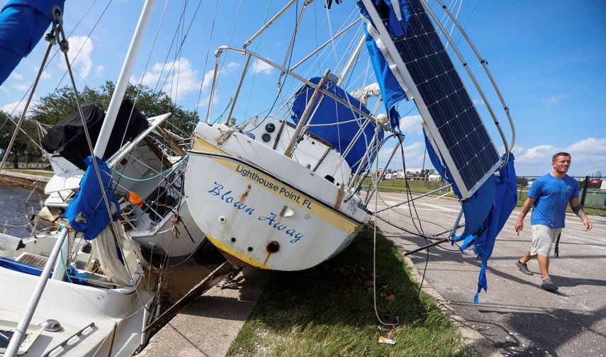 Drew Griffith camina junto a tres barcos que fueron arrastrados contra un dique tras el paso del huracán Helene en la cuenca de Seaplane de las Islas Davis, cerca del aeropuerto Peter O., el viernes 27 de septiembre de 2024 en Tampa, Florida.