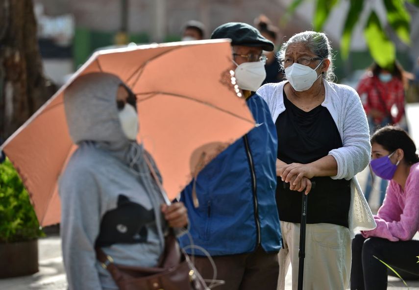La gente hace cola en el nuevo Centro C&iacute;vico del Gobierno (CCG) habilitado por el gobierno hondure&ntilde;o para atender a las personas sospechosas de estar infectadas con el nuevo coronavirus COVID-19, en Tegucigalpa, el 13 de julio de 2020.