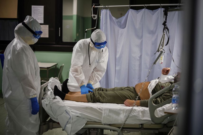 El doctor Giovanni Passeri, en el centro, con su m&eacute;dico asistente, Mariaconcetta Terracina, examina a un paciente de 55 a&ntilde;os reci&eacute;n ingreso en estado grave en su unidad para pacientes de COVID-19 en el hospital Maggiore de Parma.&nbsp;