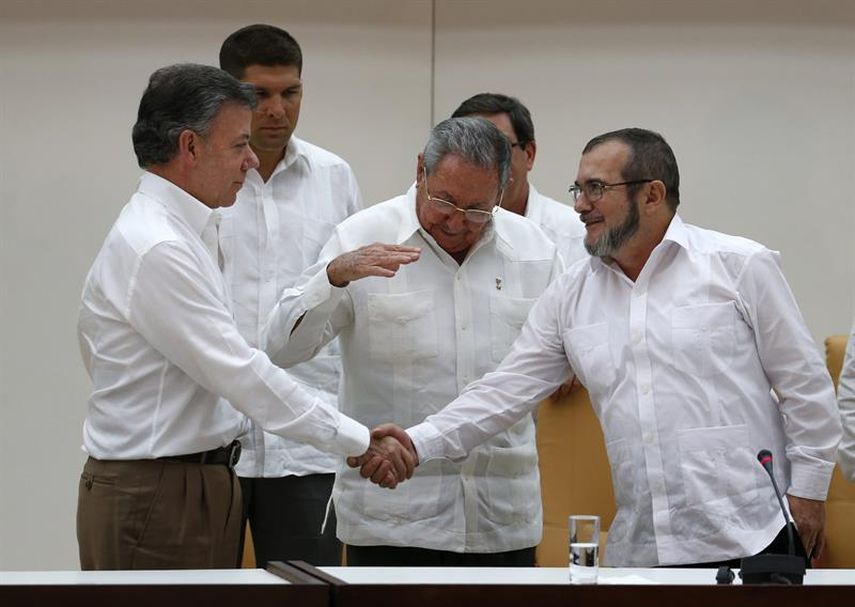 El apretón de manos entre el presidente Juan Manuel Santos y el jefe de las FARC Rodrigo Londoño refrenda la disposición de ambos para concretar el acuerdo de paz. (EFE)