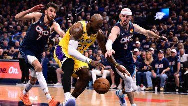 LeBron James #23 de Los Angeles Lakers lucha por el balón con Chet Holmgren #7 y Alex Caruso #9 de Oklahoma City Thunder&nbsp;