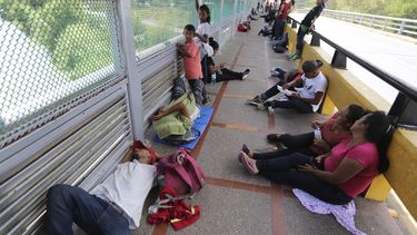 Migrantes duermen en el suelo despu&eacute;s de acampar en el Puente Internacional Gateway que conecta a Matamoros, M&eacute;xico, con Brownsville, Texas.