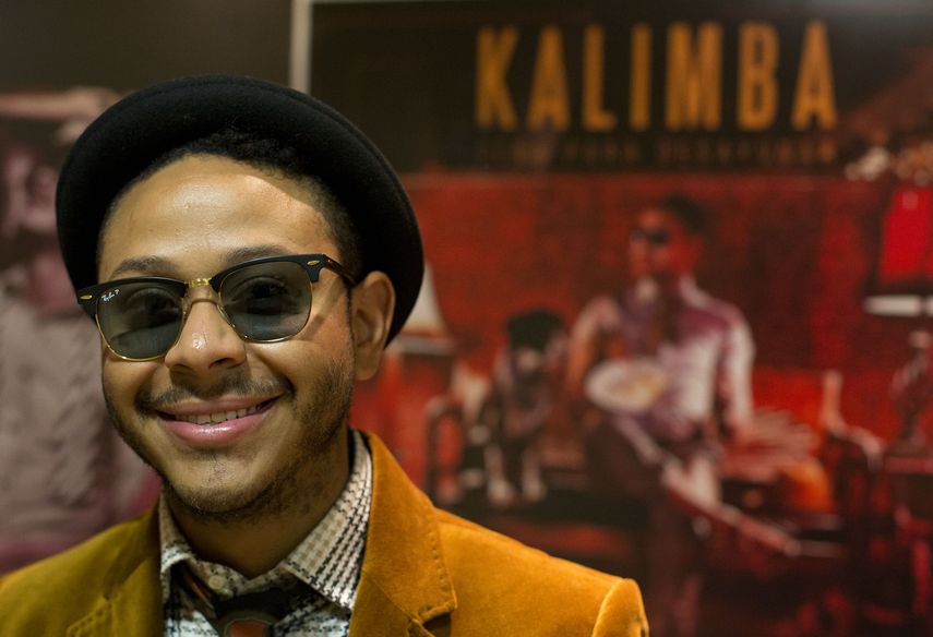 Kalimba se encuentra frente a un telón de fondo con ilustraciones de su nuevo álbum, durante una entrevista en las oficinas de Sony Music en la Ciudad de México, el jueves 10 de julio de 2014.