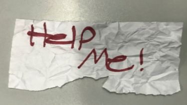 En esta fotografía sin fecha proporcionada por el Departamento de Justicia de Estados Unidos muestra un letrero con el mensaje ¡Ayúdenme! utilizado por una niña de 13 años que fue secuestrada en Texas.