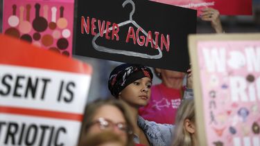 En esta imagen de archivo, tomada el 21 de mayo de 2019, August Mulvihill, de Norwalk, Iowa (centro), sostiene un cartel durante una manifestaci&oacute;n contra la ley del aborto ante la C&aacute;mara de Representantes estatal, en Des Moines, Iowa.&nbsp;