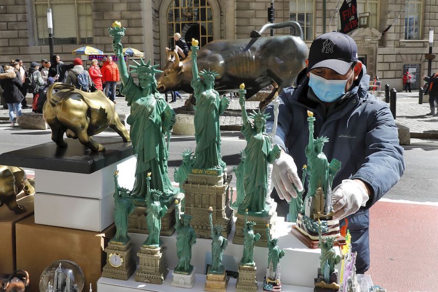 Un vendedor porta guantes y una mascarilla mientras trabaja en la ciudad de Nueva York, el domingo 15 de marzo de 2020. El temor al coronavirus se expande en toda la naci&oacute;n.&nbsp;