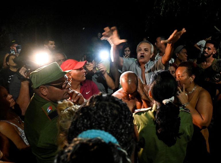 Personeros del régimen de Cuba hablan con la gente mientras protestan por la falta de energía tras el huracán Ian en La Habana, el 1 de septiembre de 2022. 