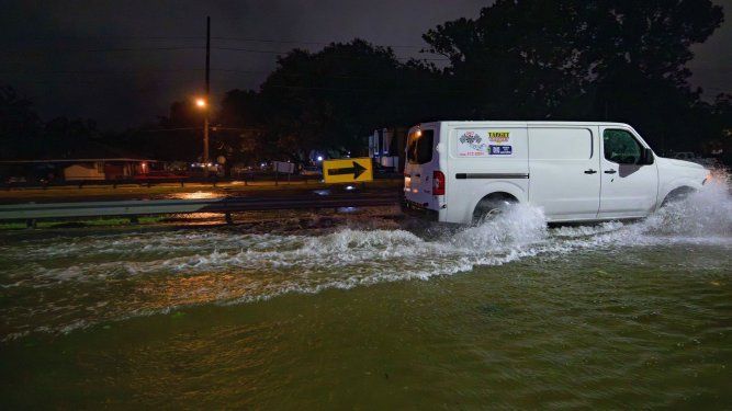 El canal de drenaje W. Napoleon Ave, tras una barandilla, se ve casi a la misma altura que la calle, cubierta por una inundación.&nbsp;