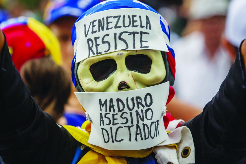 Un manifestante que porta una máscara en alusión al dictador.