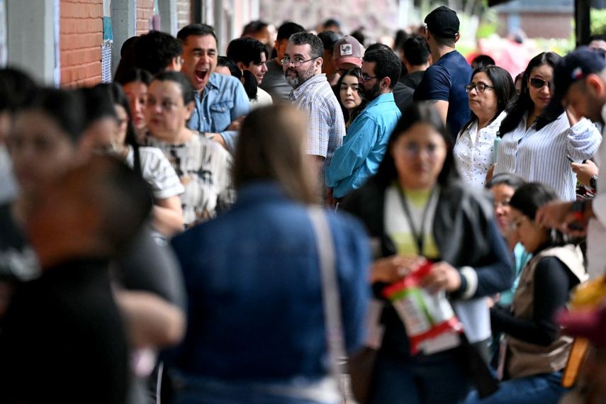 Personas hacen fila para votar en un centro de votación durante las elecciones generales en Tegucigalpa, el 30 de noviembre de 2025. Los hondureños comenzaron a votar para elegir presidente el domingo en medio de amenazas del presidente estadounidense Donald Trump de recortar la ayuda al país si su candidato preferido pierde.