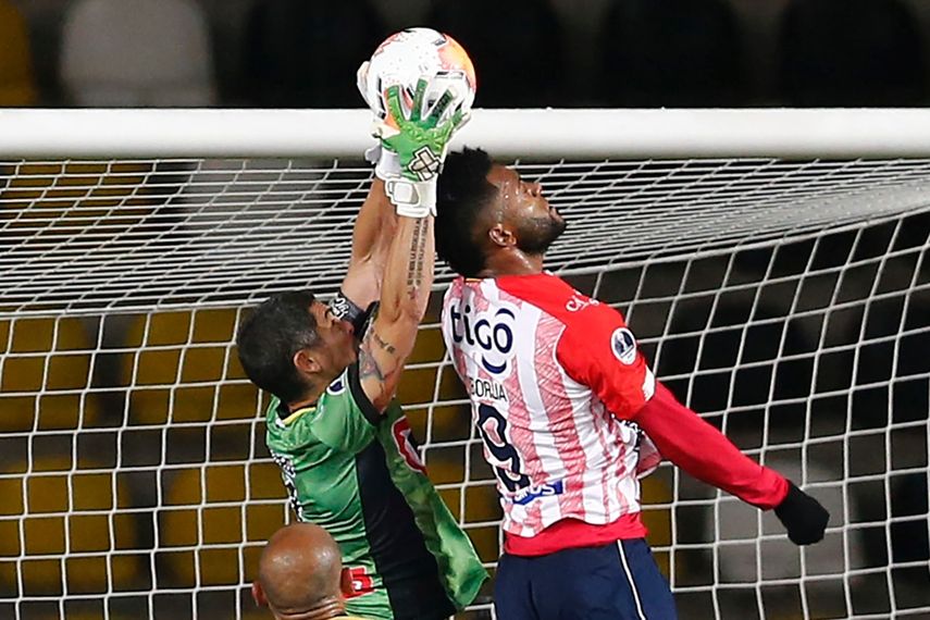 El portero argentino de Coquimbo de Chile, Matías Cano (izq.), Y el junior de Colombia, Miguel Angel Borja, compiten por el balón durante su partido de fútbol de cuartos de final de la Copa Sudamericana en el estadio Bicentenario Francisco Sánchez Rumoroso en Coquimbo, Chile, el 16 de diciembre de 2020.