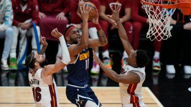 El alero de los Nuggets de Denver Bruce Brown avanza hacia la canasta mientras lo defienden el alero Caleb Martin y el base Kyle Lowry del Heat de Miami en el juego 4 de las Finales de la NBA el viernes 9 de junio del 2023.&nbsp;