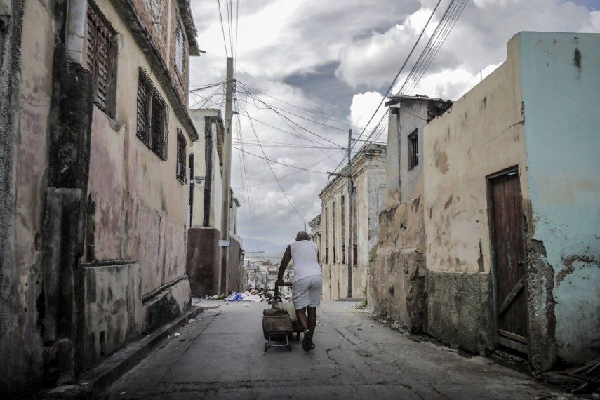 Un hombre arrastra una carretilla cargada de agua por una calle en Santiago de Cuba, Cuba.