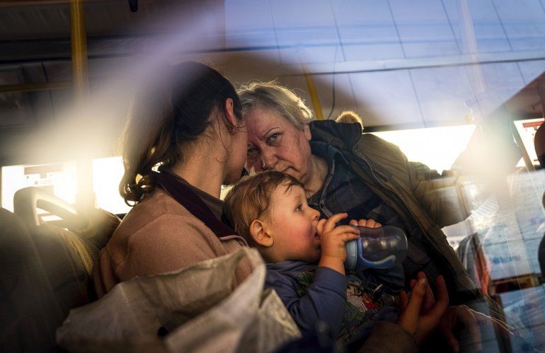 Personas con niños esperan tras llegar desde la ciudad ucraniana de Mariúpol en un centro para desplazados en Zaporiyia, el martes 3 de mayo de 2022. 