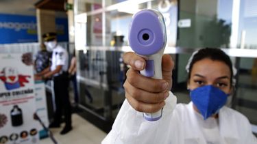 Una mujer toma la temperatura a un fot&oacute;grafo en un centro comercial de Brasilia, el mi&eacute;rcoles 27 de mayo de 2020.