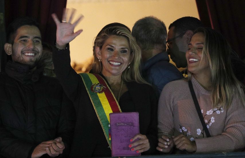 La segunda vicepresidenta del Senado de Bolivia y senadora de la oposici&oacute;n Jeanine &Aacute;&ntilde;ez, en el centro, saluda a la multitud ataviada con la banda presidencial en el balc&oacute;n del palacio de Quemado, tras proclamarse presidenta interina del pa&iacute;s, en la Paz, Bolivia, el martes 12 de noviembre de 2019.&nbsp;