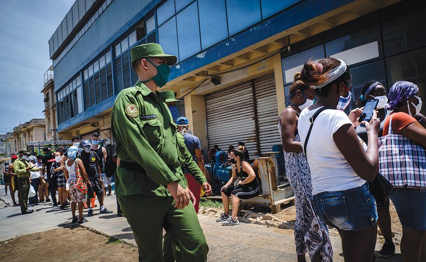 Un soldado vigila las afueras de una tienda en La Habana.
