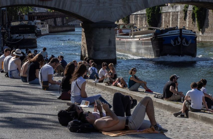Unas personas se sientan en la orilla del r&iacute;o Sena en Par&iacute;s, el jueves 28 de mayo de 2020.&nbsp;