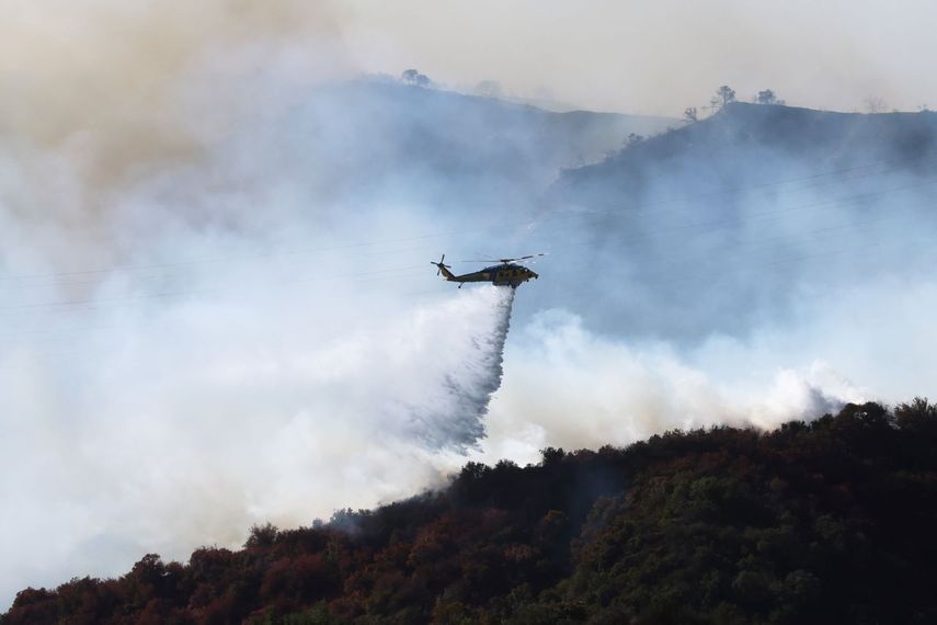 El agua cae desde un helicóptero mientras el incendio crece cerca de Encino Hills, California, el 11 de enero de 2025.