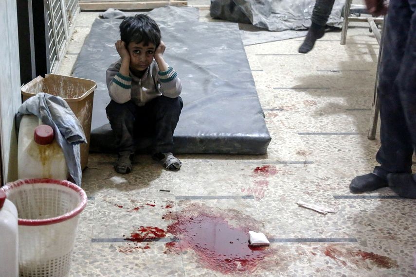 Un niño herido espera a recibir tratamiento médico junto a un charco de sangre en un hospital de campaña, tras un ataque aéreo perpetrado supuestamente por las fuerzas leales al gobierno sirio en la ciudad sitiada de Doum.