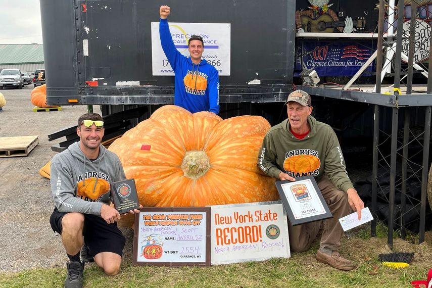 De izq a der: Emmett Andrusz, Steve Andrusz y Scott Andrusz con la calabaza gigante en Clarence, Nueva York, el 1 de octubre del 2022.