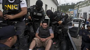 Plutarco Ruiz, esposado y con un chaleco blinddo, es escoltado por la policía a un tribunal para una audiencia en Santa Bárbara, Honduras (Foto AP)