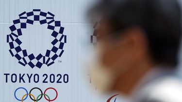 un hombre con una mascarilla pasa por delante del logo de los Juegos Ol&iacute;mpicos de Tokio 2020, en Tokio.&nbsp;