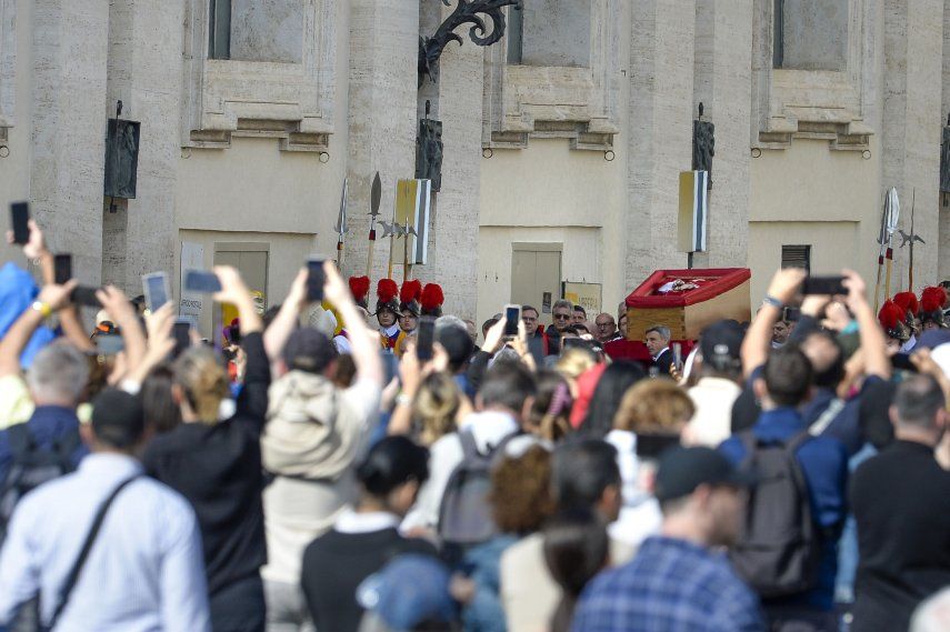 Cientos de personas observan la llegada del féretro del Papa Francisco I a la Basílica de San Pedro, a 23 de abril de 2025, en Ciudad del Vaticano.&nbsp;&nbsp;
