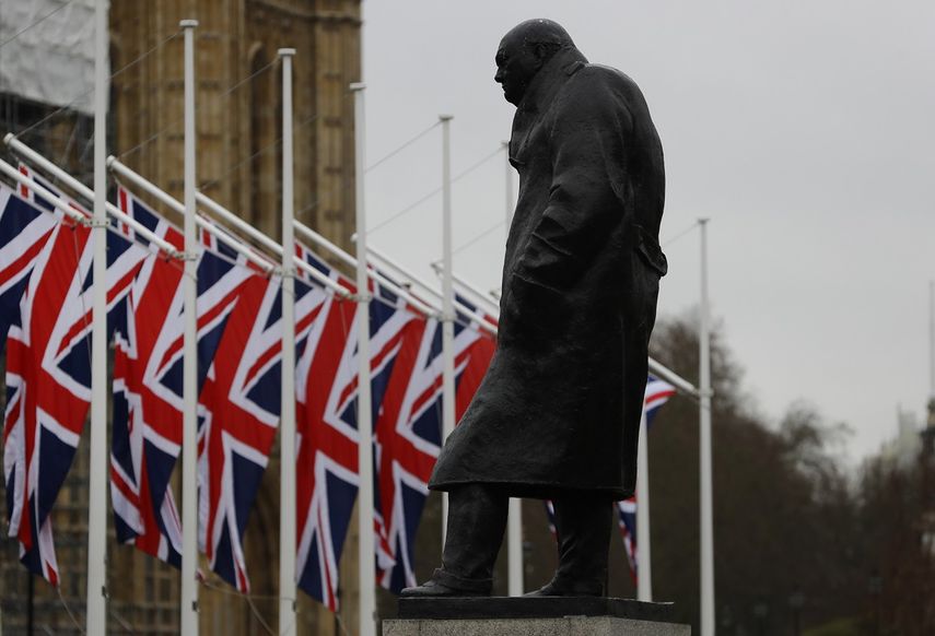 Banderas brit&aacute;nicas ondean en el exterior del parlamento brit&aacute;nico, cerca de la estatua de Winston Churchill, en Londres, el 30 de enero de 2020, en la v&iacute;spera de la salida de Gran Breta&ntilde;a de la Uni&oacute;n Europea.&nbsp;