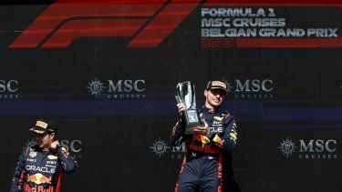 El piloto holandés de Red Bull Racing, Max Verstappen (der.), celebra con su trofeo flanqueado por el segundo clasificado, el piloto mexicano de Red Bull Racing, Sergio Pérez, en el podio después de ganar el Gran Premio de Bélgica de Fórmula 1 en el circuito de Spa-Francorchamps en Spa el 30 de julio de 2023. . &nbsp;