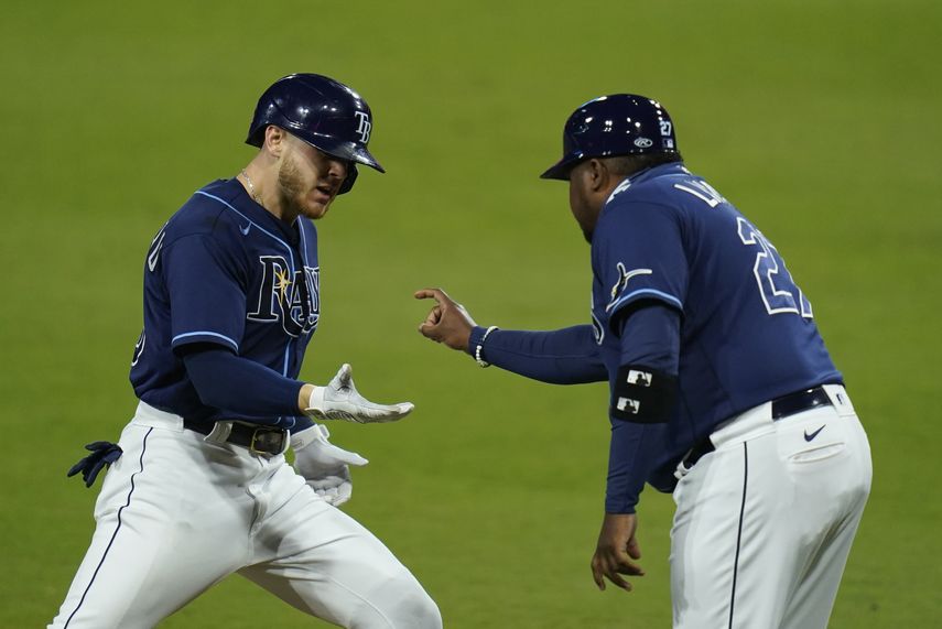 Michael Brosseau es felicitado por el coach de la antesala Rodney Linares, tras conectar un jonr&oacute;n solitario por los Rays de Tampa Bay en el quinto partido de la serie divisional ante los Yanquis de Nueva York, el viernes 9 de octubre de 2020&nbsp;